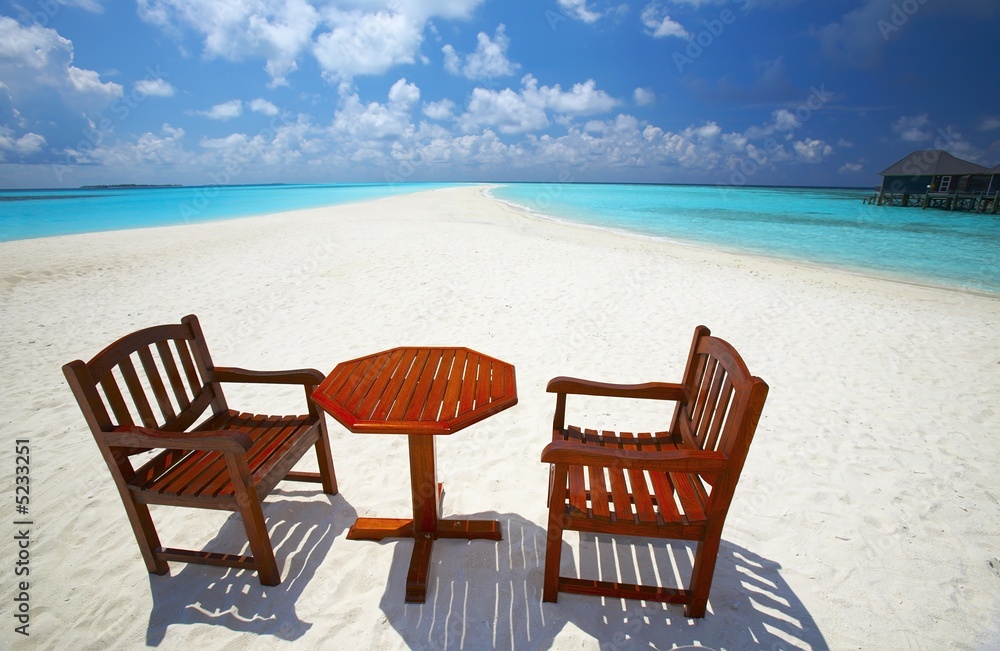 Chairs and  table are on the beach