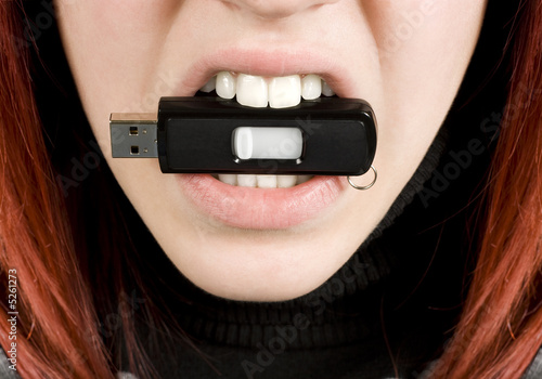 Girl biting an usb flash drive