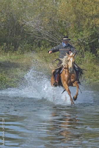 American cowboy charging into river