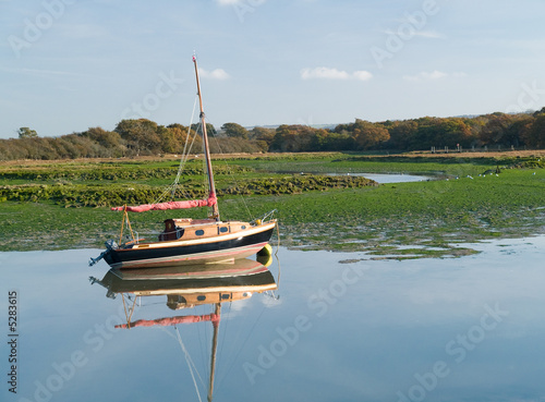 Fototapeta Old style sailing boat in marshland waters