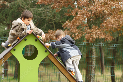 petits enfants entrain de jouer dans une aire de jeux photo