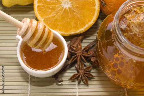 fresh honey with honeycomb, spices and fruits photo