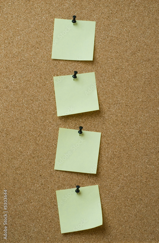 four yellow notes pinned to cork background four yellow notes pinned to cork background