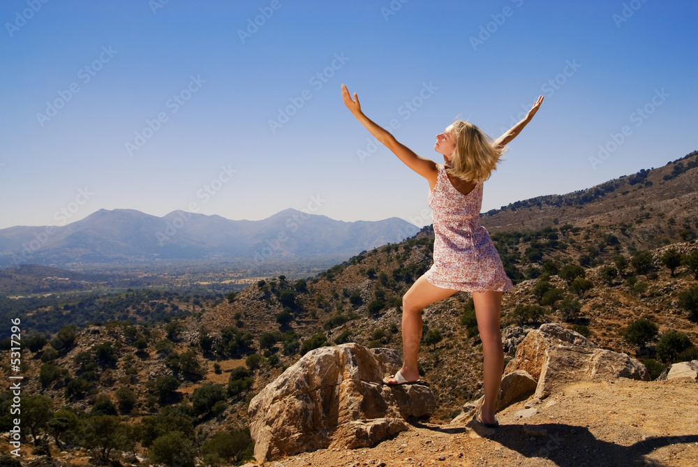 Beautiful girl standing on a mountain with her hands wide open Beautiful girl standing on a mountain with her hands wide open