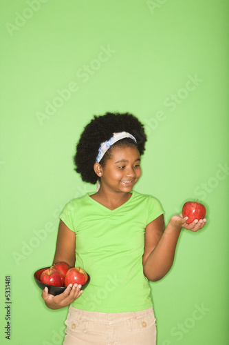 African American girl holding apples.