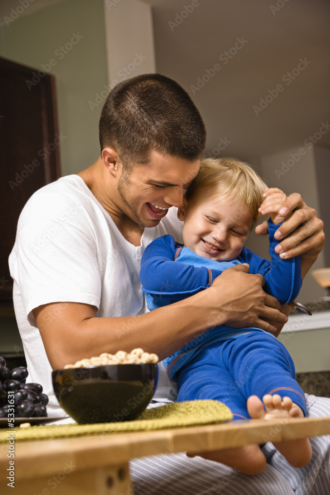 Dad tickling son. Dad tickling son.