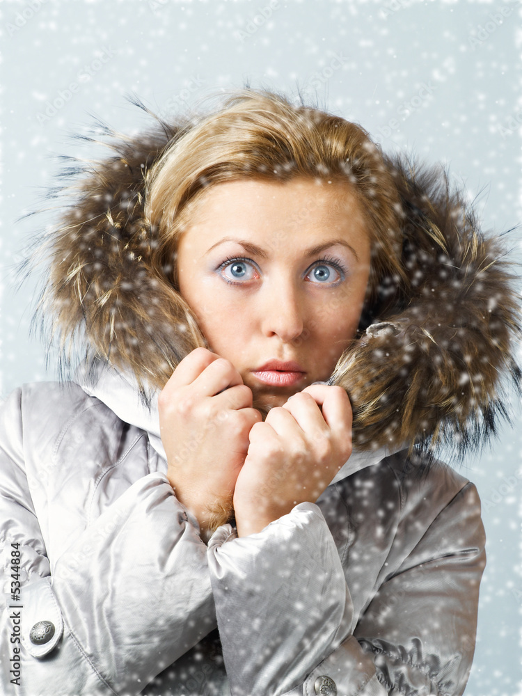 Young women in fur hood with worried expression on face in snow Young women in fur hood with worried expression on face in snow