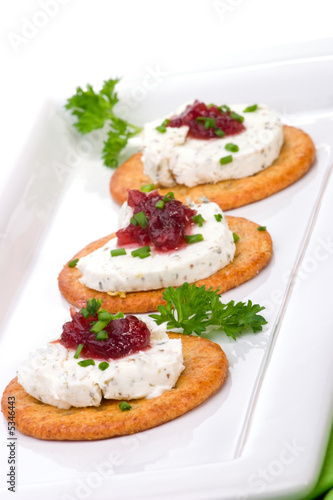 Three crackers with goat cheese and cranberry orange sauce