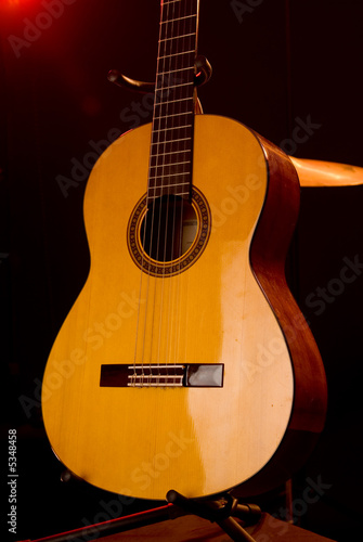 An acoustic guitar on a stand on a stage