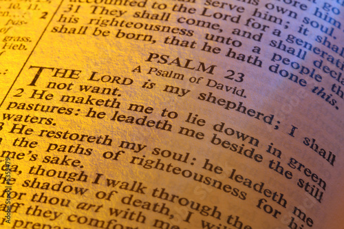 Close-up of Bible page showing Psalm 23. Warm lighting.