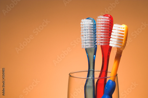 A family s toothbrushes in a glass container.