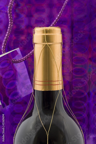 A wine bottle with gift wrapping and tag