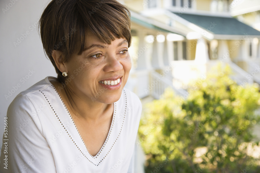 African American middle aged woman outside home smiling.