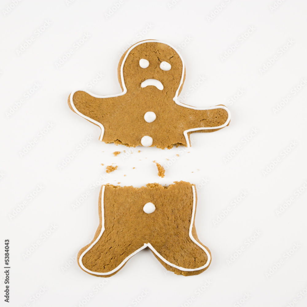 Frowning male gingerbread cookie broken in half. Frowning male gingerbread cookie broken in half.