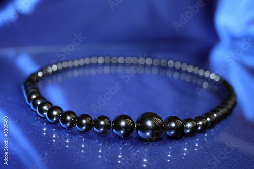 Beads from black corals cubano on the blue background