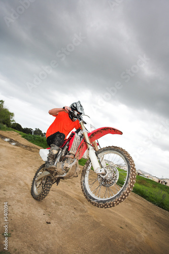 Young man riding around on his dirtbike doing tricks 