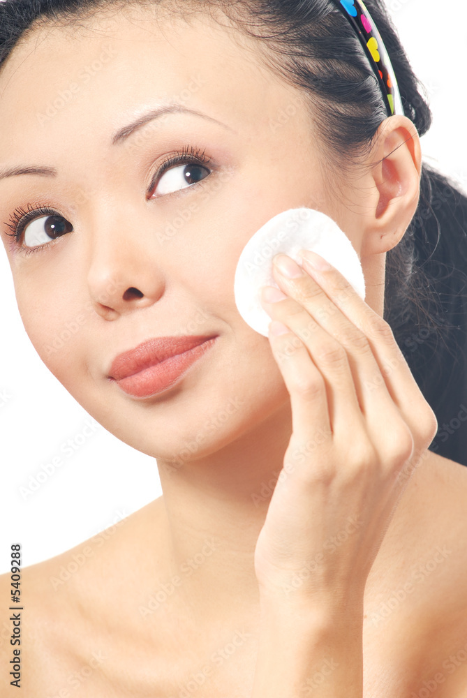 Brunette with cleaning pad on her face Brunette with cleaning pad on her face