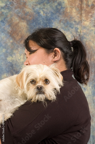 Asian woman holding pet dog in arms