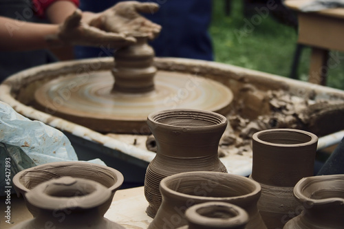 Potter working with clay bowl on potter s wheel