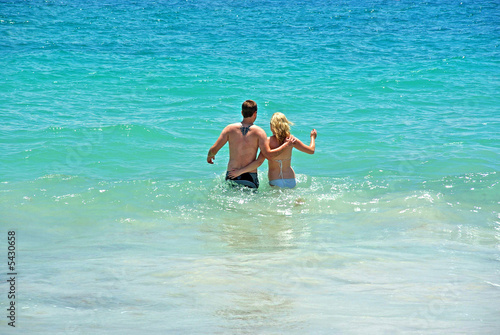 A couple frolic in the water at a Perth beach.