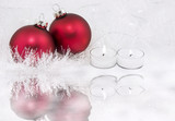 Candles and red Christmas ornaments on ice