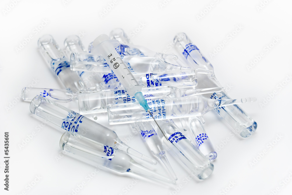 The syringe lays on a heap of ampoules with a medicine. The syringe lays on a heap of ampoules with a medicine.