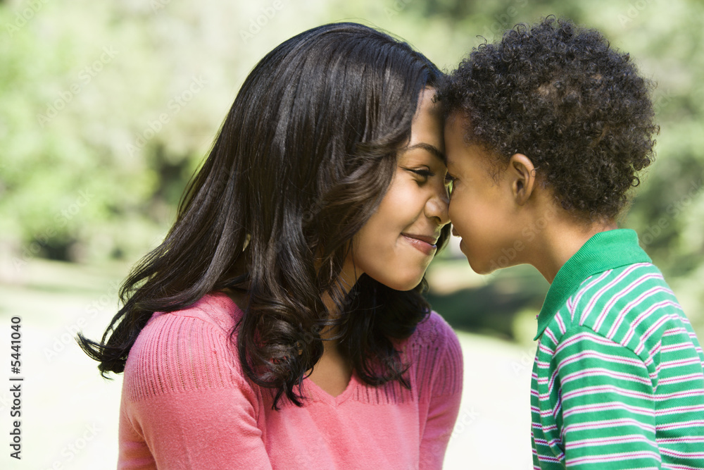 Mother and young son with heads together smiling. Mother and young son with heads together smiling.