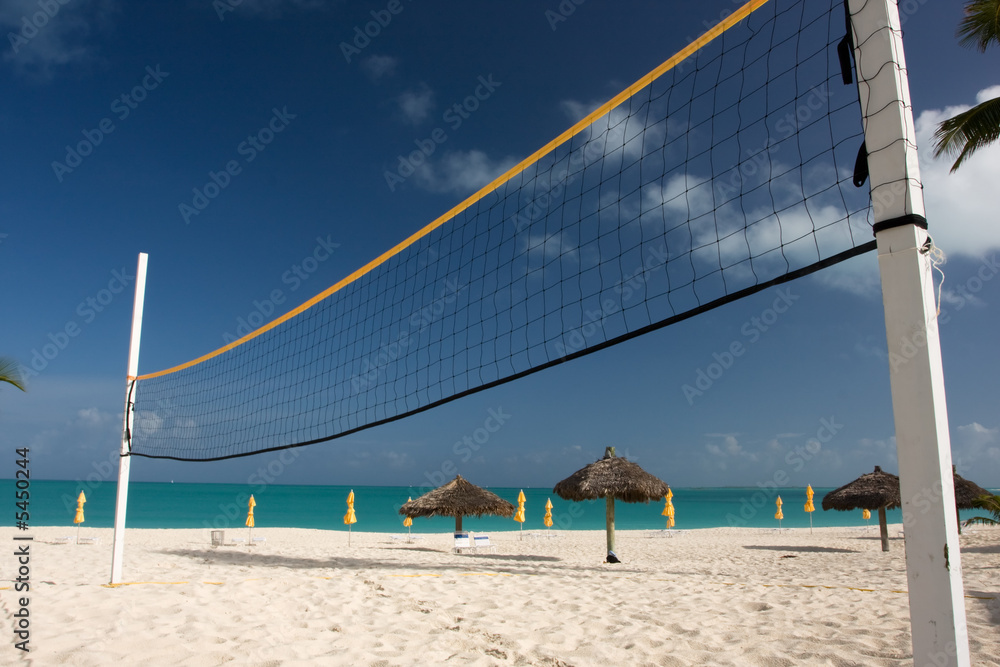 sun beds with thatched sun shade on beach with turquoise sea sun beds with thatched sun shade on beach with turquoise sea