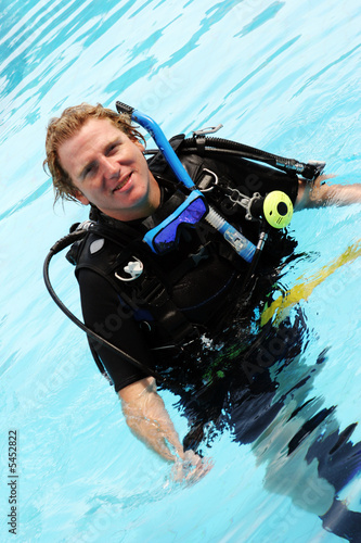 Happy scuba diving instructor in the swimming pool.