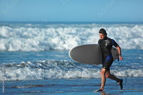 Young man running with a serfboard