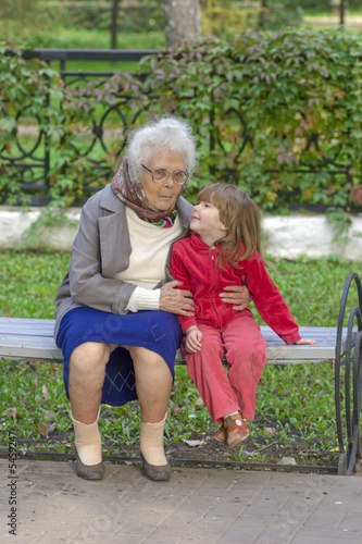 Great Grandmother talking to grandchild sitting on the bench