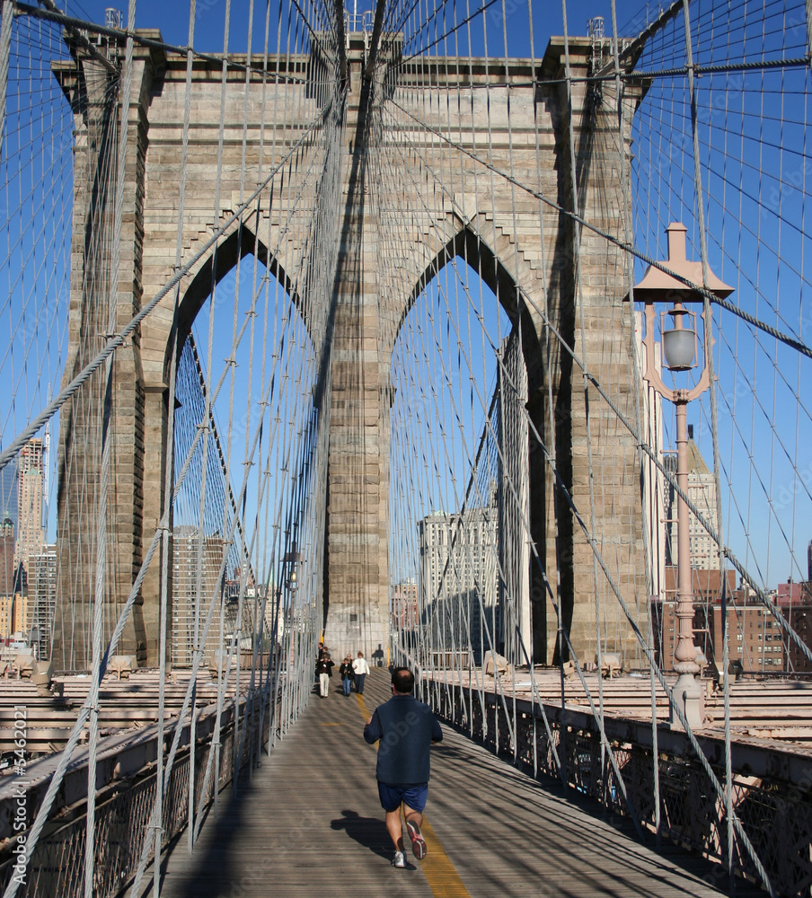 Fototapeta premium man jogging across Brooklyn Bridge New York City