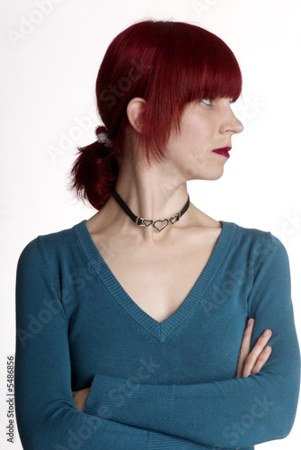 a serious woman with folded arm and red hair