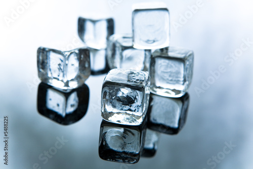 Melting ice cubes on reflective background