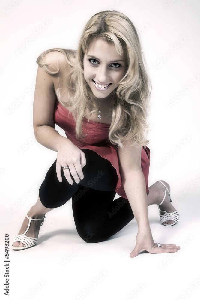 Studio portrait of a long blond girl on one knee Studio portrait of a long blond girl on one knee