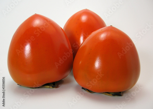 3 organic hachiya persimmons isolated on white.
