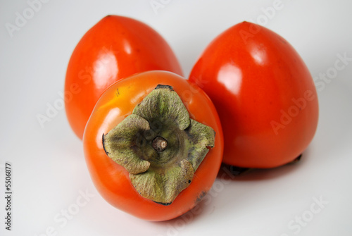 three hachiya persimmons, isolated on white.