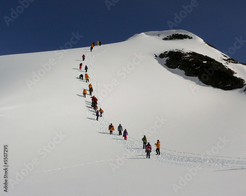 a parade of colorful jackets heading up a hill in antarctica