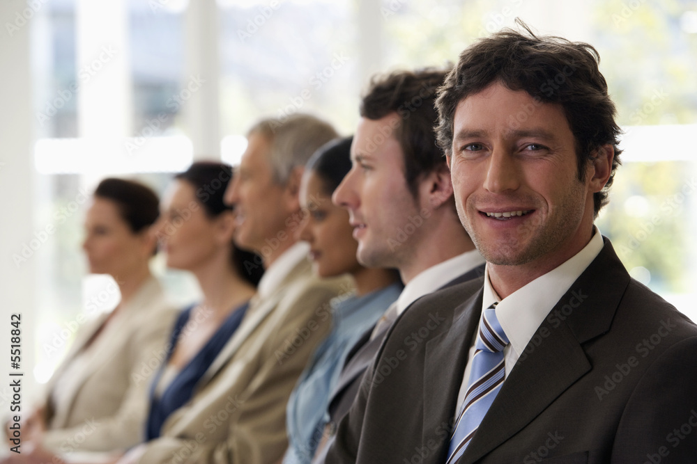 Confident businessman with team behind him Confident businessman with team behind him