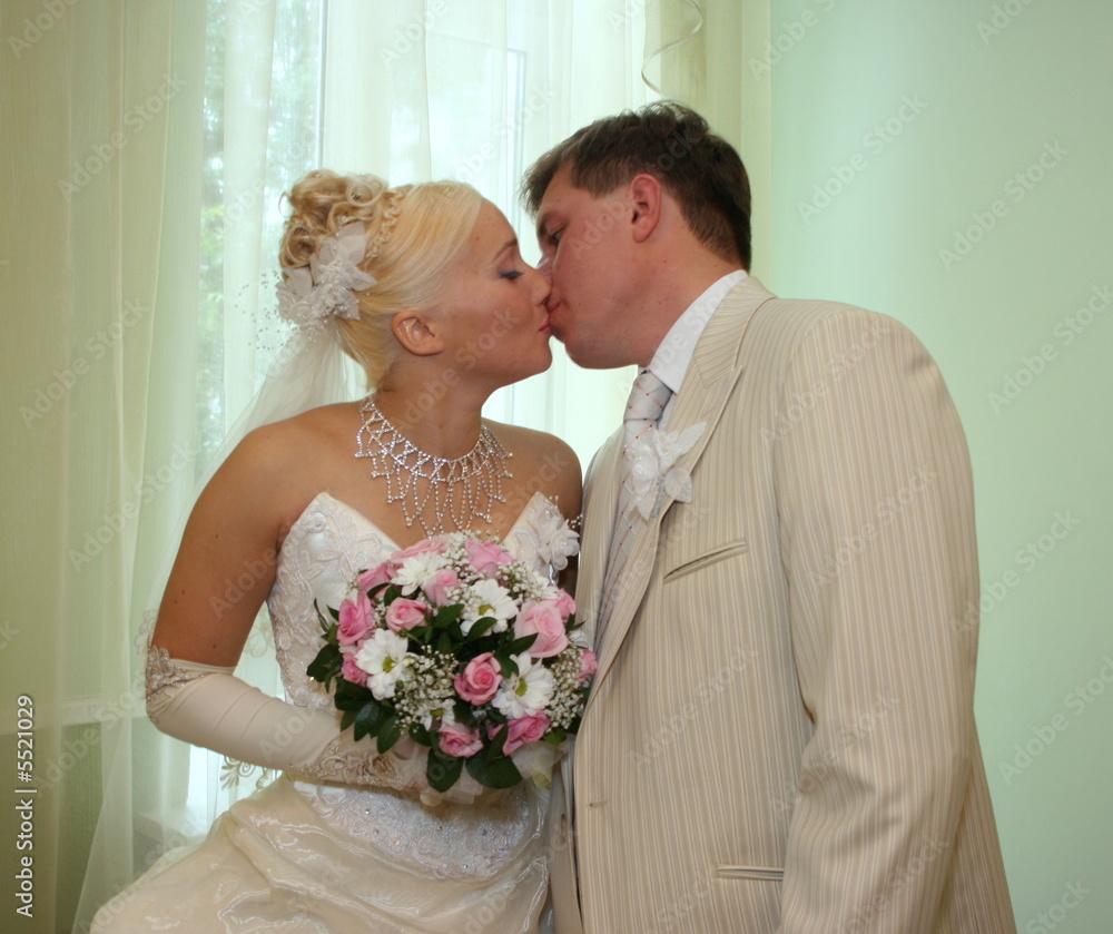 Wedding kiss of young newlyweds couple Wedding kiss of young newlyweds couple