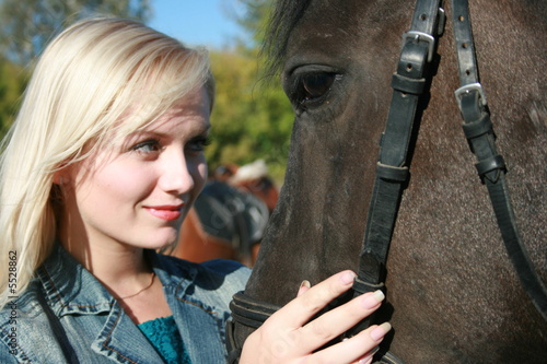 Blond female model with brown horse close-up portrait