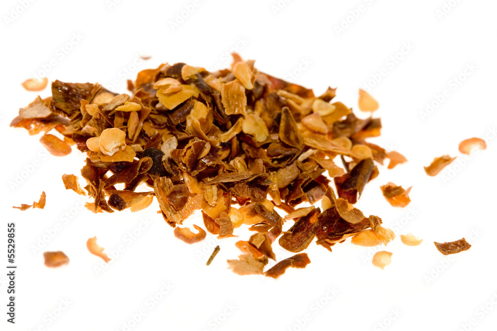 A small pile of crushed red pepper isolated on white.