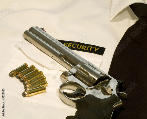 revolver and seven bullets laying on a white security shirt