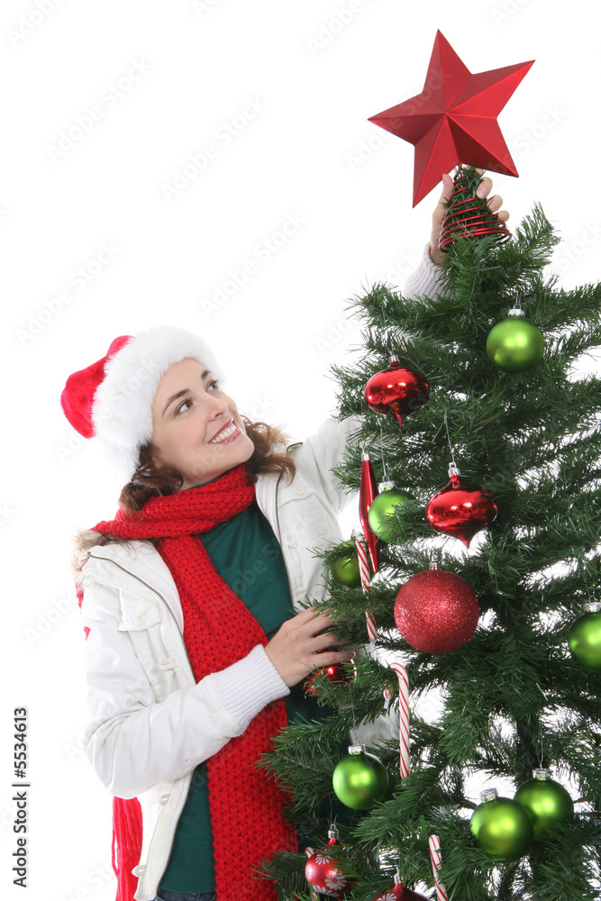 A pretty woman putting a star on the Christmas tree