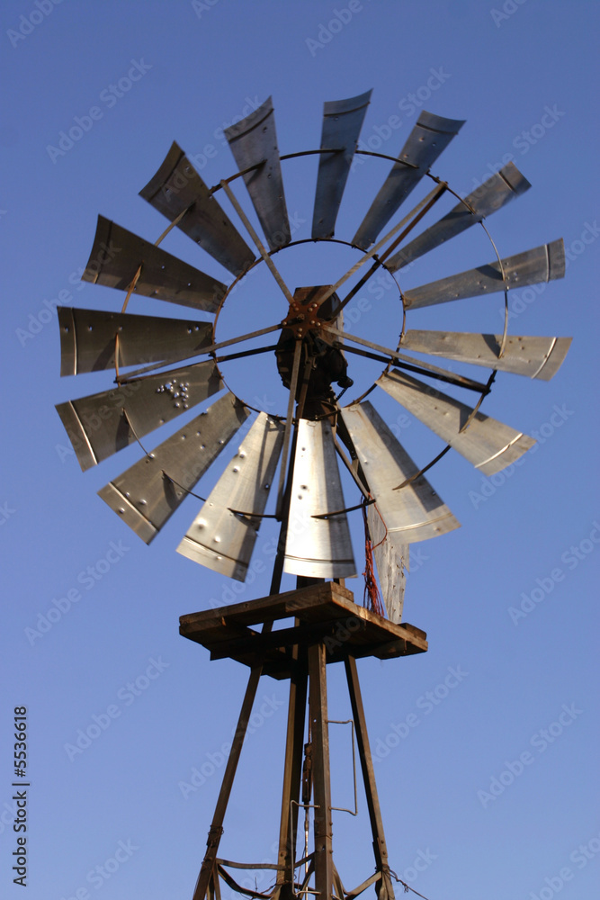 An old windmill still pumping water on a cattle ranch An old windmill still pumping water on a cattle ranch
