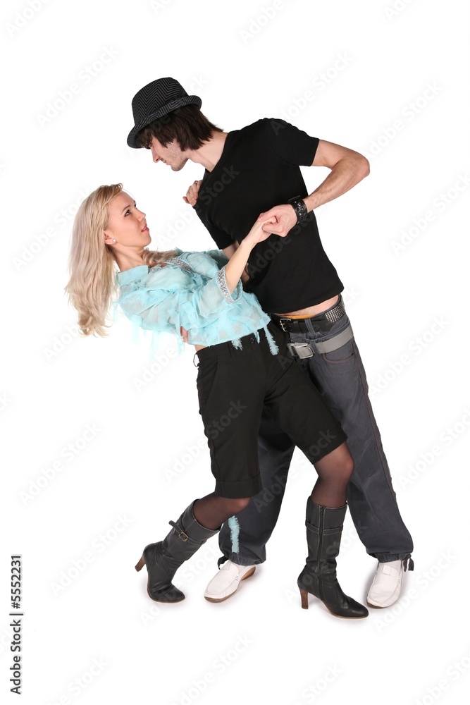 girl in cyan blouse dances with boy in black hat on white