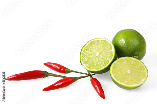 Limes and chilli peppers, isolated on white.  