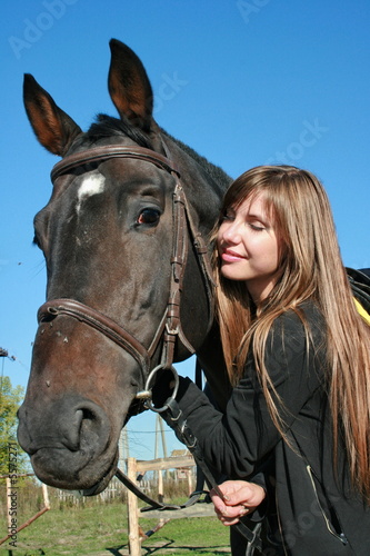 Long-haired female model with black horse close-up portrait