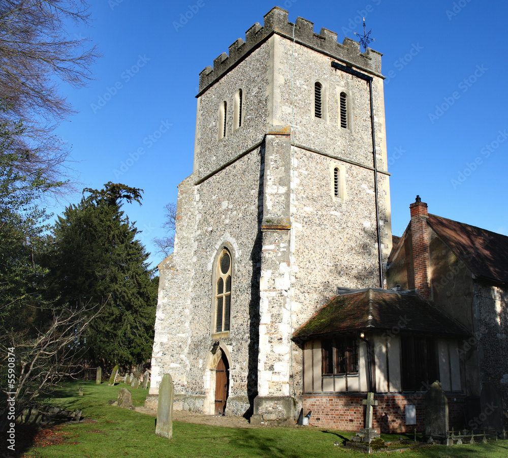 Naklejka premium Medieval English Village Church against a clear blue Winter sky