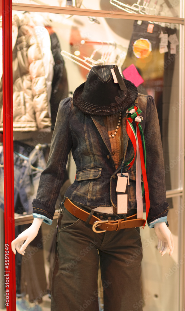 Woman mannequin in front of a clothes shop in a city.